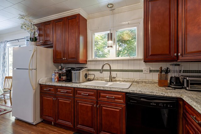 kitchen featuring white fridge, ornamental molding, sink, black dishwasher, and hardwood / wood-style flooring