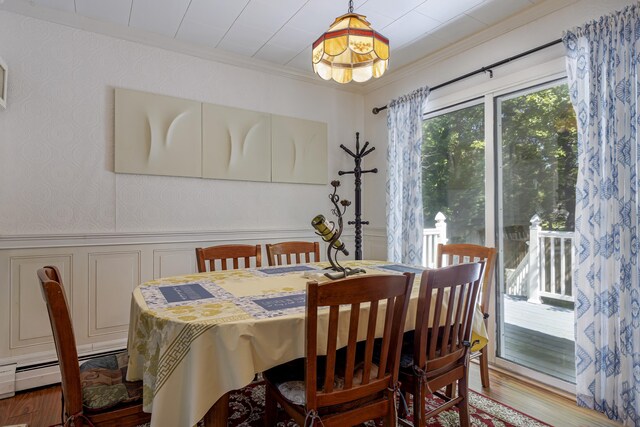 dining space featuring ornamental molding and hardwood / wood-style flooring