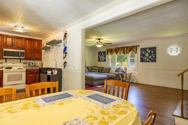 dining room featuring crown molding, dark wood-type flooring, a baseboard radiator, and ceiling fan