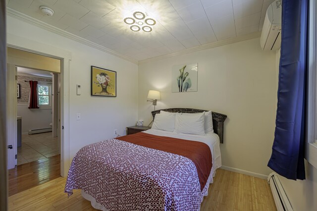 bedroom with light wood-type flooring, a baseboard heating unit, and a wall mounted air conditioner