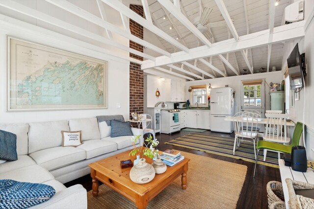 living room with dark hardwood / wood-style flooring, lofted ceiling with beams, and sink