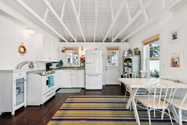 kitchen featuring dark hardwood / wood-style flooring, beamed ceiling, white appliances, and white cabinetry