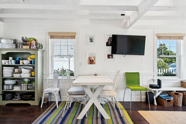 dining space with dark wood-type flooring, plenty of natural light, and beam ceiling