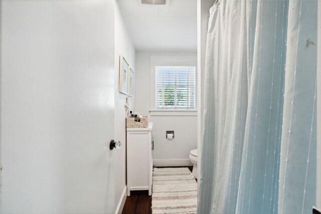 bathroom featuring vanity, toilet, hardwood / wood-style floors, and walk in shower