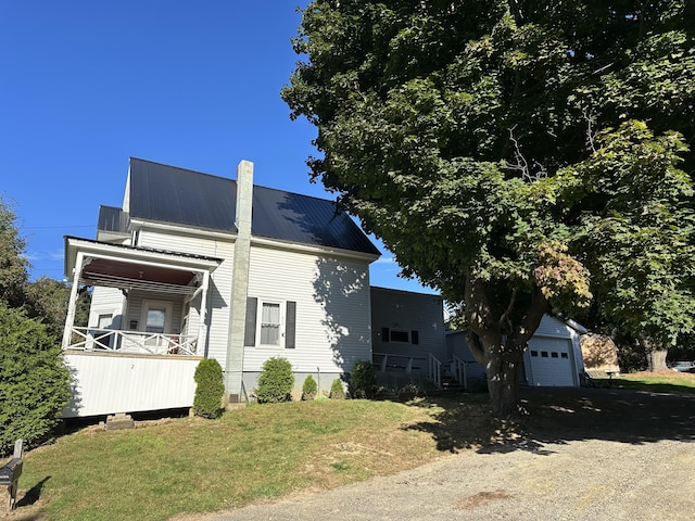 view of side of property with a garage, a yard, and an outdoor structure