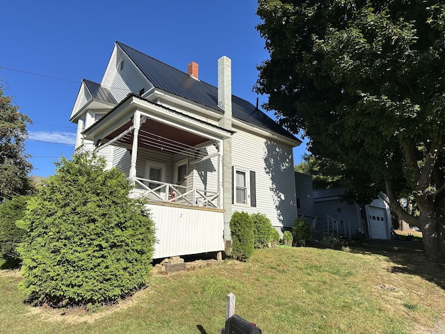 view of side of property featuring a garage and a yard