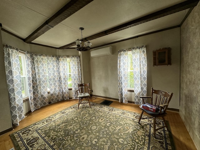 2 Lincoln St, Houlton, ME 04730 - living area featuring a wall unit AC, beamed ceiling, wood finished floors, a chandelier, and baseboards