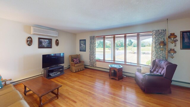 living room with a baseboard heating unit, plenty of natural light, and a wall mounted air conditioner