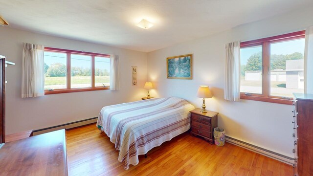 bedroom featuring baseboard heating and light wood-type flooring