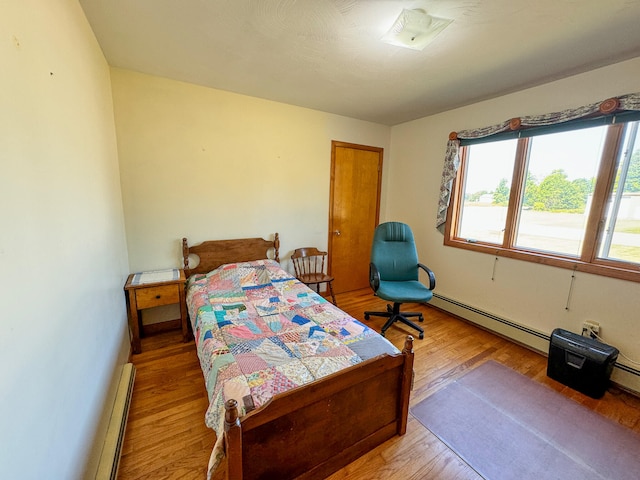 bedroom with wood-type flooring and a baseboard radiator