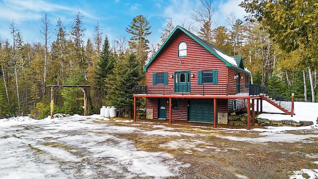 exterior space with stairs, log veneer siding, an attached garage, and a wooden deck