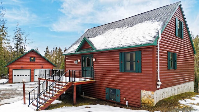 log cabin featuring a garage, a shingled roof, an outdoor structure, and stairs