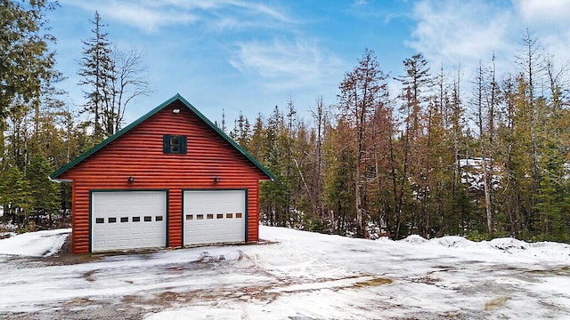 snow covered garage with a detached garage