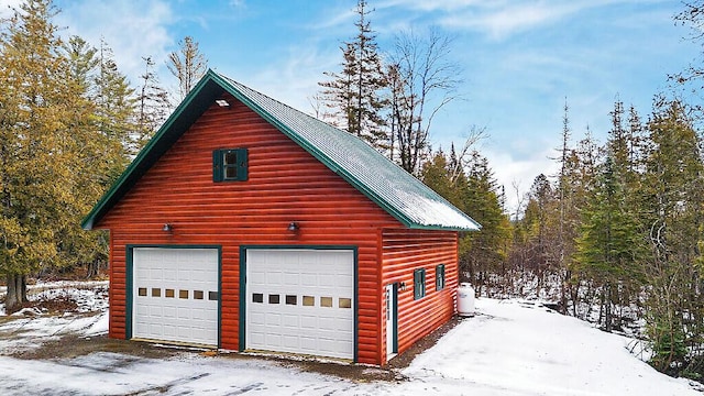 snow covered garage with a garage