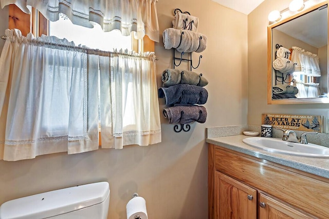 half bathroom featuring vanity and toilet