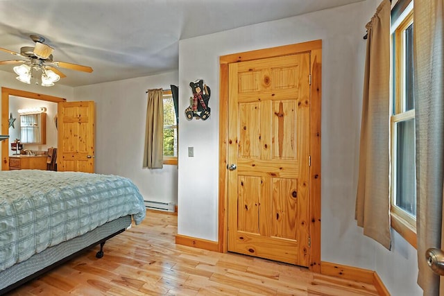 bedroom featuring ceiling fan, baseboard heating, light wood-type flooring, and baseboards