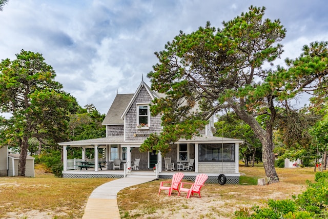 view of front of house with a sunroom and a front yard