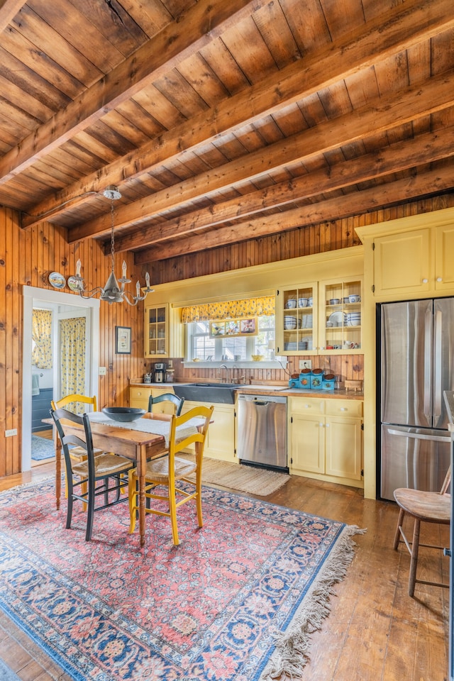 dining space featuring beamed ceiling, wood ceiling, wood-type flooring, wooden walls, and a notable chandelier