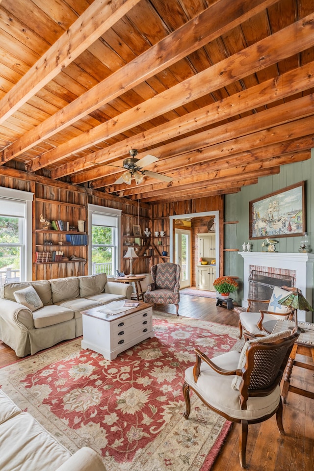 living room featuring hardwood / wood-style flooring, plenty of natural light, wood walls, and a brick fireplace