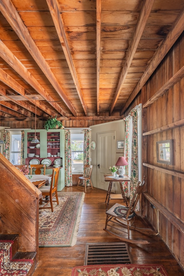 interior space with wood ceiling, wooden walls, beamed ceiling, and dark wood-type flooring