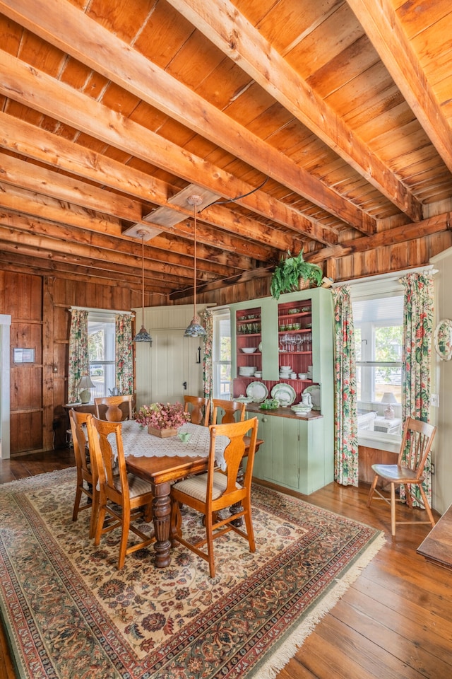 dining space featuring wood ceiling, hardwood / wood-style floors, wood walls, and a healthy amount of sunlight