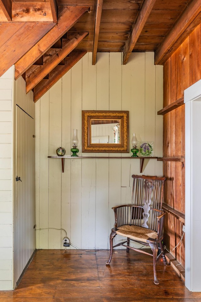 living area with wooden ceiling, vaulted ceiling with beams, wood walls, and wood-type flooring