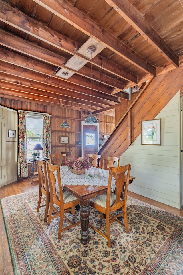 dining space featuring light hardwood / wood-style floors, wood ceiling, and wood walls