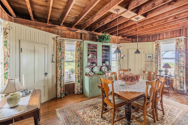 dining area featuring wood-type flooring, wood ceiling, wood walls, and beam ceiling