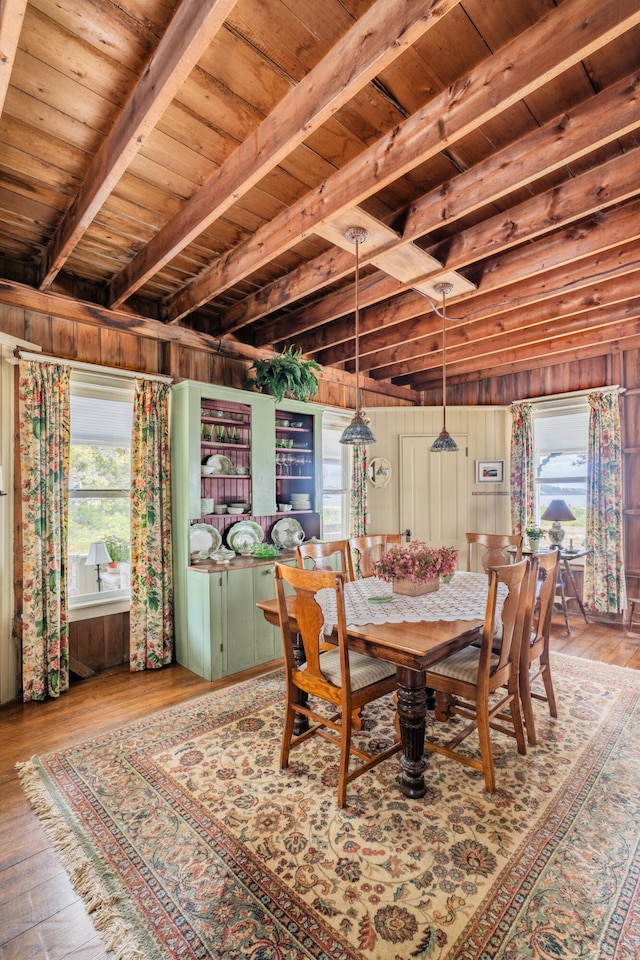 dining room featuring light hardwood / wood-style flooring, wooden ceiling, and a wealth of natural light