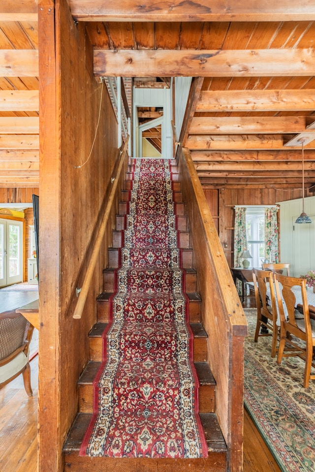 stairway with wood ceiling and beamed ceiling