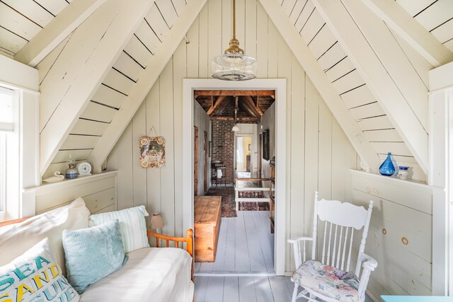 living room featuring wood walls, vaulted ceiling, and hardwood / wood-style floors