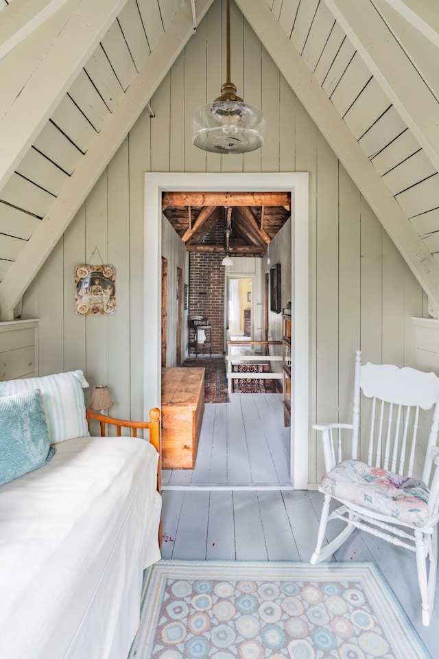 bedroom featuring lofted ceiling with beams and wood walls