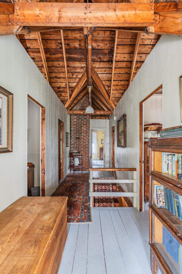 miscellaneous room with wooden walls, light wood-type flooring, lofted ceiling with beams, and wooden ceiling