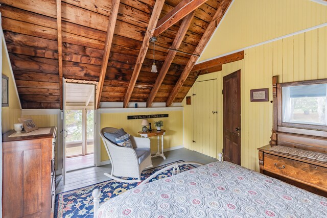 unfurnished bedroom with multiple windows, vaulted ceiling with beams, and hardwood / wood-style flooring