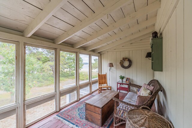 sunroom / solarium featuring lofted ceiling with beams, wood ceiling, and a healthy amount of sunlight