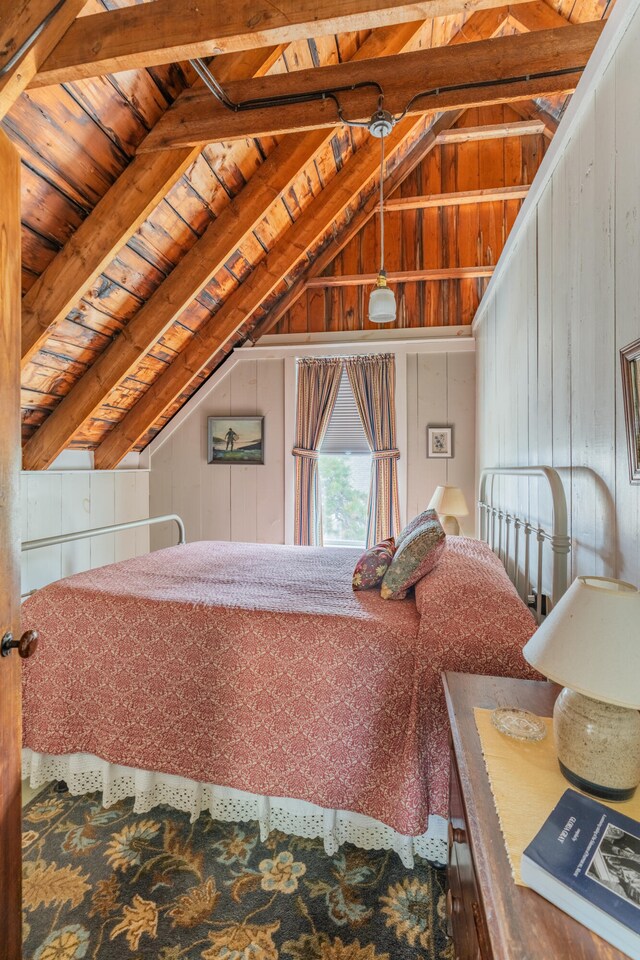 bedroom featuring wooden walls, lofted ceiling with beams, and wooden ceiling