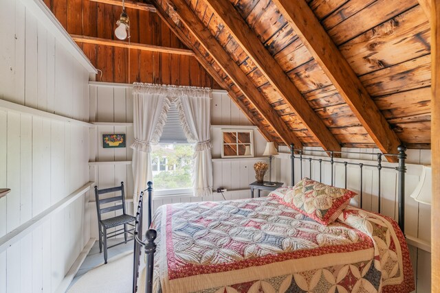 bedroom with vaulted ceiling with beams, wooden walls, and wood ceiling