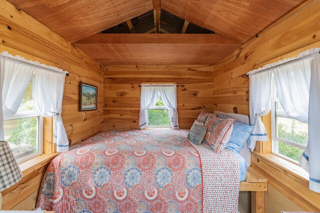 bedroom with wood ceiling, wooden walls, and vaulted ceiling