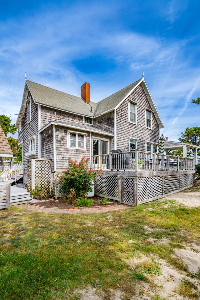 rear view of house with a deck and a yard