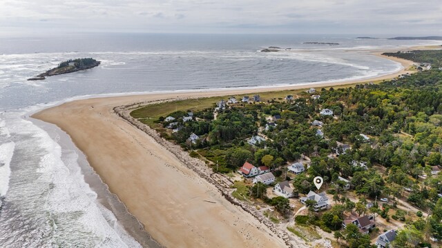 birds eye view of property with a water view and a beach view