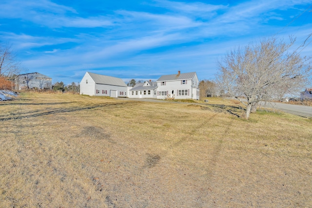 view of front of property featuring a front lawn, a chimney, and metal roof