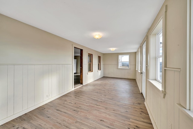 empty room featuring wainscoting and wood finished floors