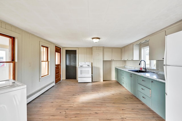 kitchen with a sink, a baseboard heating unit, white appliances, and light wood-style flooring