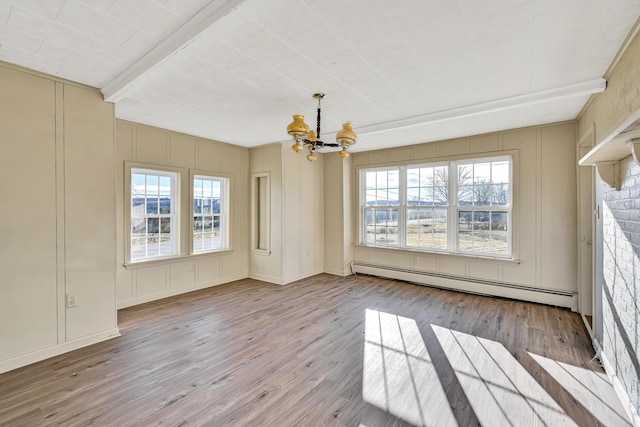 unfurnished dining area with wood finished floors, a baseboard radiator, a decorative wall, a notable chandelier, and a wealth of natural light