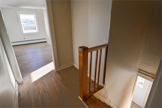 stairs with a baseboard radiator and wood finished floors