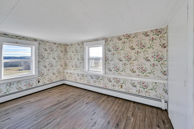 unfurnished room with wood finished floors, baseboards, a baseboard radiator, wallpapered walls, and crown molding