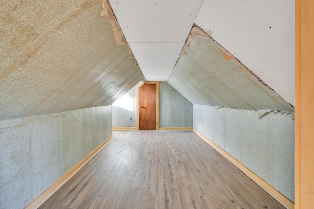 bonus room featuring vaulted ceiling and wood finished floors