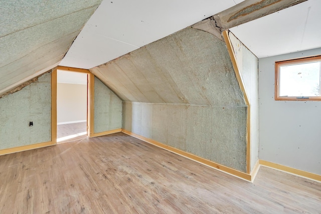 bonus room with wood finished floors and vaulted ceiling