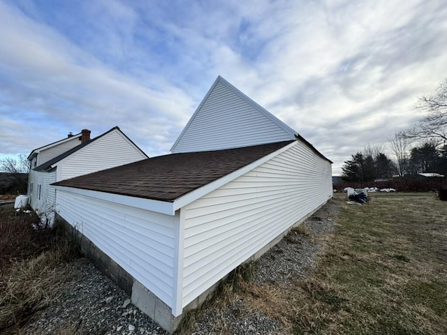 view of side of property featuring roof with shingles