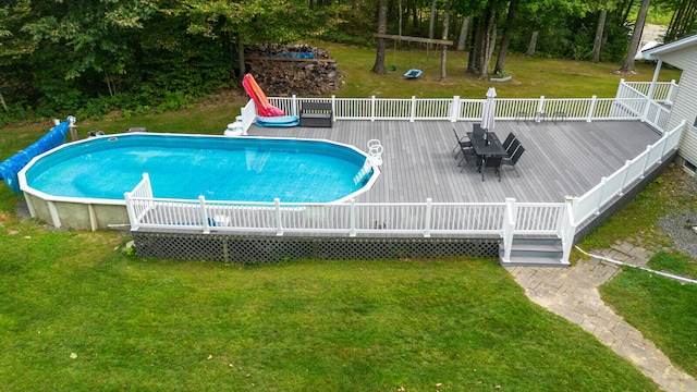 view of pool with a lawn and a deck